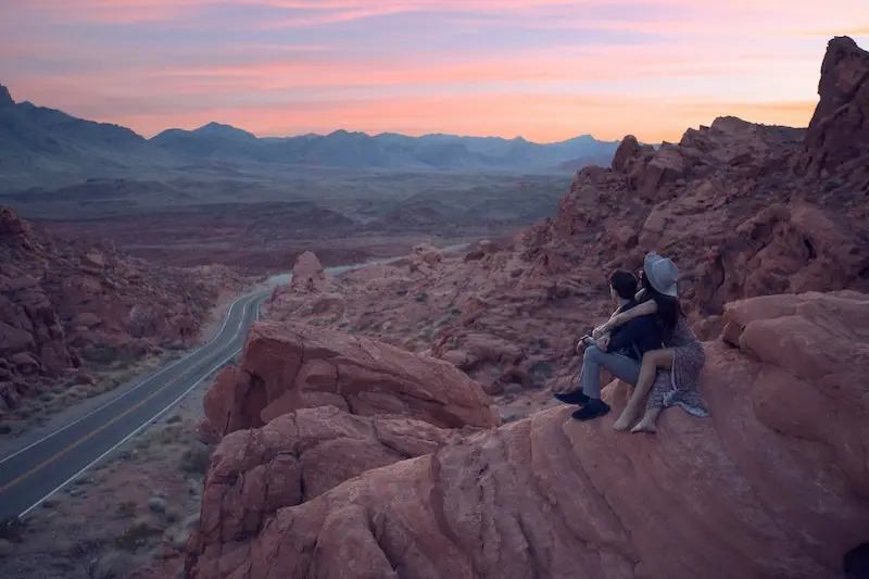 Couple sitting on the edge of a cliff