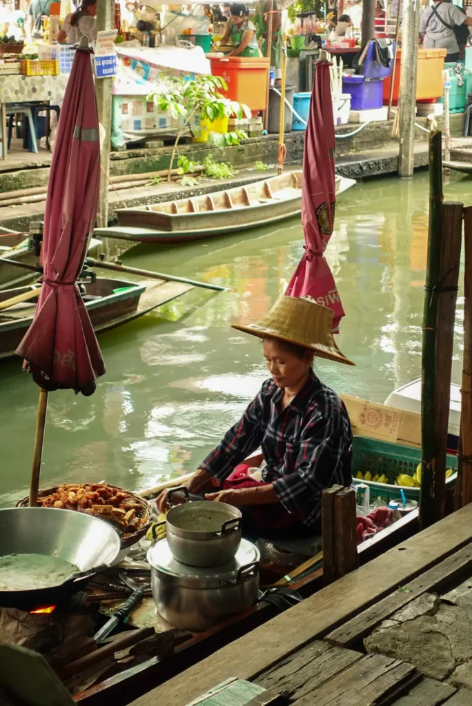 A Thai lady cooking on a boat